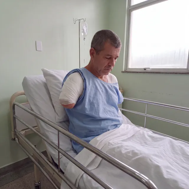 Marcelo sentado na cama